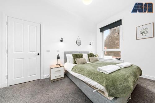 a white bedroom with a large bed and a window at 2 Bed Home with Parking Sleeps 4 in Fife