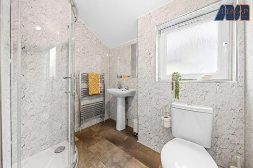 a bathroom with a toilet and a shower and a sink at 2 Bed Home with Parking Sleeps 4 in Fife