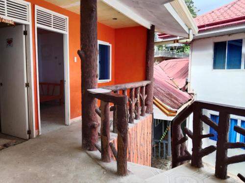 a balcony of a house with an orange wall at WJV Inn Beach Resort Camotes in Camotes Islands