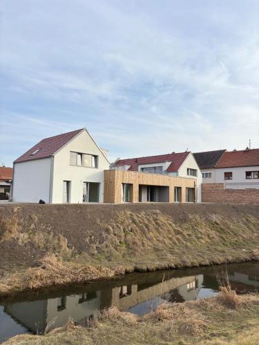 a group of houses in a subdivision with a body of water at Domus Cobile in Kobylí