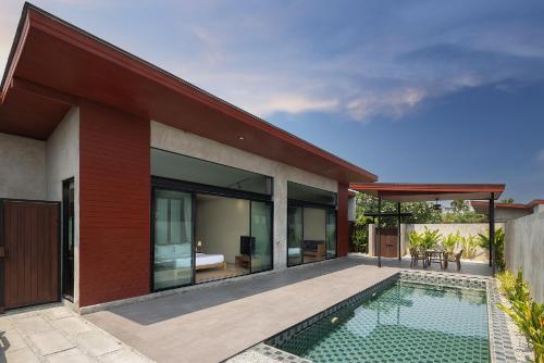an external view of a house with a swimming pool at Sunday Sea Two Pool Villa Pattaya in Jomtien Beach