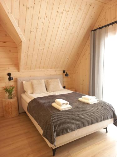 a bedroom with a bed with two towels on it at Domek z bali Zakopane in Zakopane
