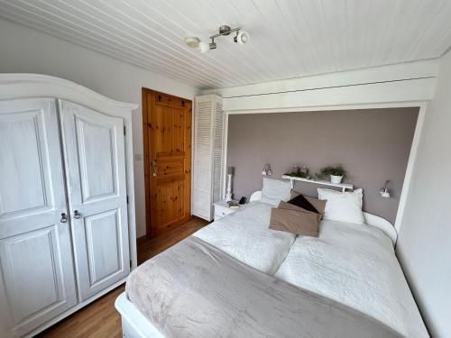 - une chambre blanche avec un grand lit blanc et des oreillers blancs dans l'établissement Ferienhof-Wohler-Wohnung-1, à Bojendorf