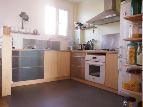 - une cuisine équipée d'appareils électroménagers en acier inoxydable et d'une cuisinière dans l'établissement Lumineux, calme, charme villageois à 2mn du métro parisien, à Malakoff