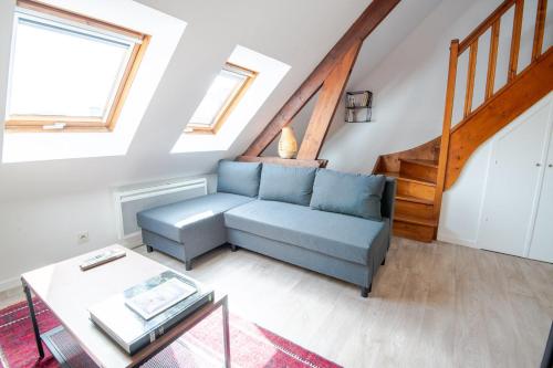 un salon avec un canapé bleu et une table dans l'établissement Le Duplex de Richelieu, à Tours