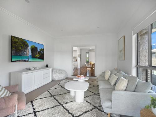 a living room with a couch and a table at Serene Luxury Retreat on Malua Bay in Malua Bay