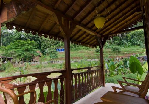 porche de madera con vistas al jardín en Villa Couple by Santosa Stable Resort, en Gunungpati