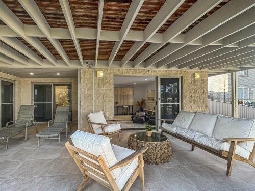 a living room with a couch and chairs at Serene Luxury Retreat on Malua Bay in Malua Bay