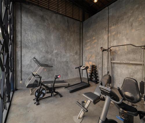 a gym with several exercise equipment in a room at Sunday Sea Two Pool Villa Pattaya in Jomtien Beach