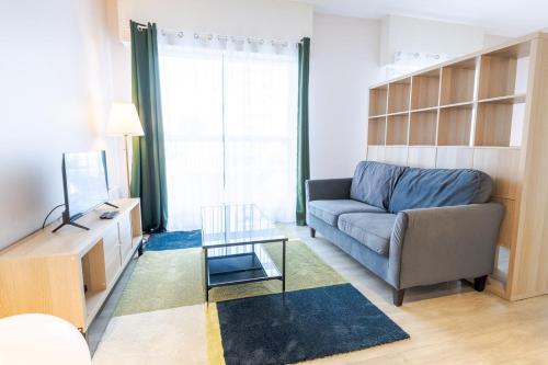 un salon avec un canapé et une table en verre dans l'établissement Le Tribut, à Tours