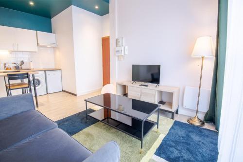 un salon avec un canapé et une table dans l'établissement Le Tribut, à Tours