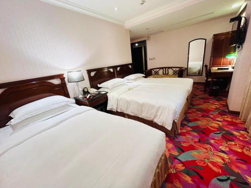 a hotel room with two beds and a mirror at Royal Seasons Hotel Taipei ‧ Nanjing W. in Taipei