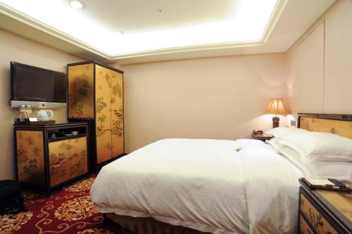 a hotel room with a bed and a flat screen tv at Royal Seasons Hotel Taipei ‧ Nanjing W. in Taipei