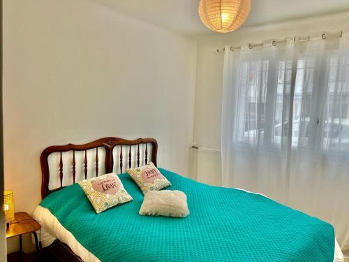 une chambre avec un lit avec deux oreillers dessus dans l'établissement Les Bleuets YourHostHelper, à Cagnes-sur-Mer