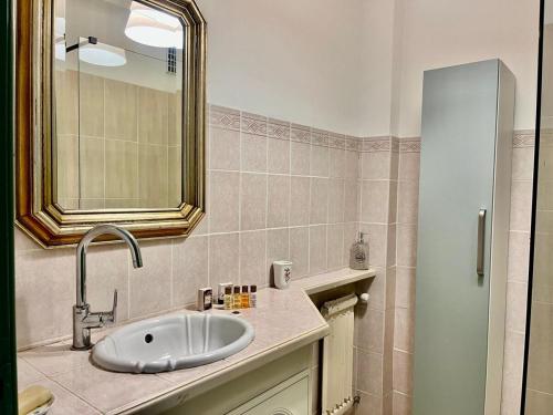 une salle de bain avec un lavabo et un miroir dans l'établissement Les Bleuets YourHostHelper, à Cagnes-sur-Mer