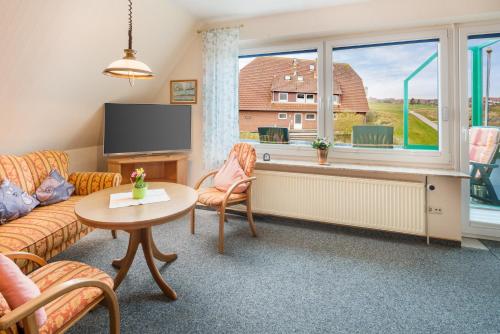 a living room with a couch and a tv and a table at Ferienwohnung "Hellerblick" in Baltrum