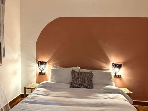 a bedroom with a large bed with a brown headboard at Apartment 3 min walking Airport sania Ramel in Tetouan