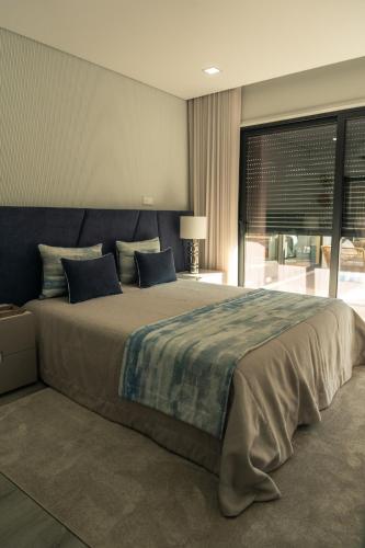 a bedroom with a large bed and a large window at Vietnam House in Barcelos