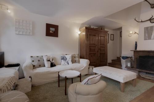 a living room with white furniture and a fireplace at Le Bedux - Privée - Calme - Terrasse - Vues in Chamonix-Mont-Blanc