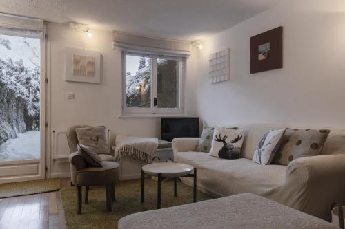 a living room with a couch and chairs and a tv at Le Bedux - Privée - Calme - Terrasse - Vues in Chamonix-Mont-Blanc