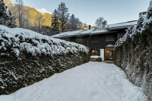 a snow covered yard next to a house at Le Bedux - Privée - Calme - Terrasse - Vues in Chamonix-Mont-Blanc