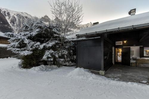 a building covered in snow with a tree in front of it at Le Bedux - Privée - Calme - Terrasse - Vues in Chamonix-Mont-Blanc