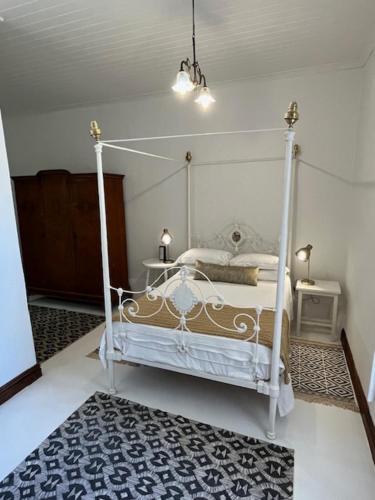 a bedroom with a white canopy bed and a rug at The Prime Spot Self Catering in Worcester