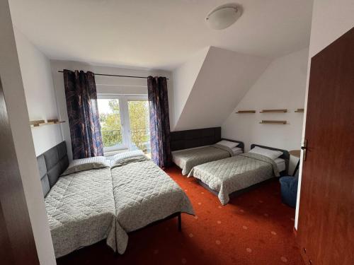 a attic room with three beds and a window at Tasarz 2 in Rewal