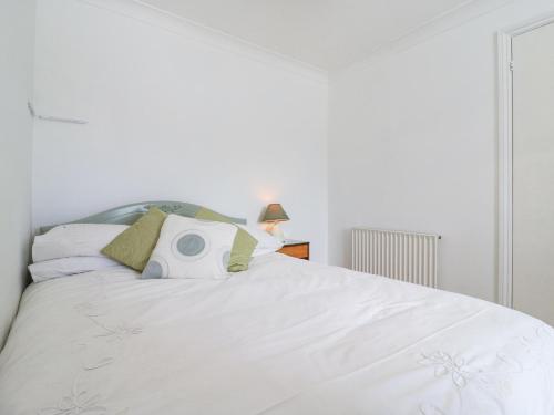 a bedroom with a large white bed with a pillow on it at Twynholm in Sheerness