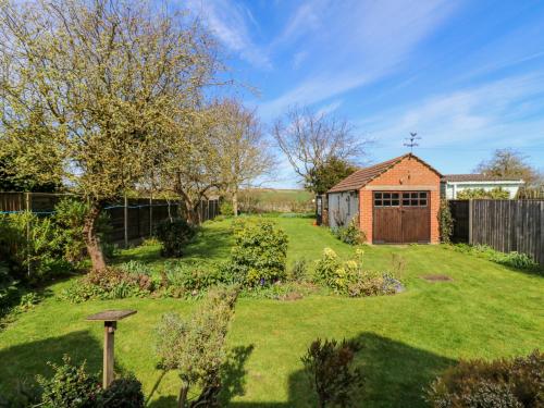 a garden with a small shed and a fence at Twynholm in Sheerness