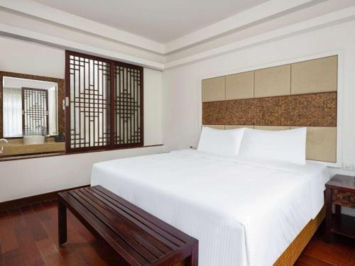 a bedroom with a large white bed and a window at Grand Mercure Sanya Yalong Bay in Sanya