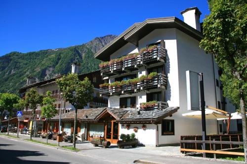 a building with flowers on the balconies on a street at Hotel Les Jumeaux Courmayeur in Courmayeur