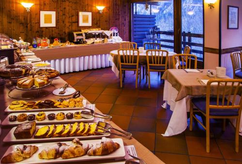 a buffet line with many different types of food at Hotel Les Jumeaux Courmayeur in Courmayeur