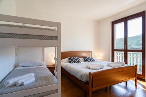 a bedroom with two bunk beds and a window at La grande Valsassina - Salone in Pasturo