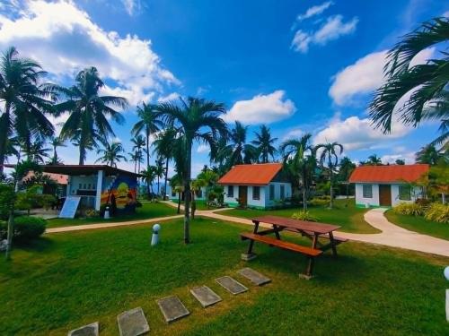 a picnic table in a park with palm trees at Galaxy Family Room in Dalaguete