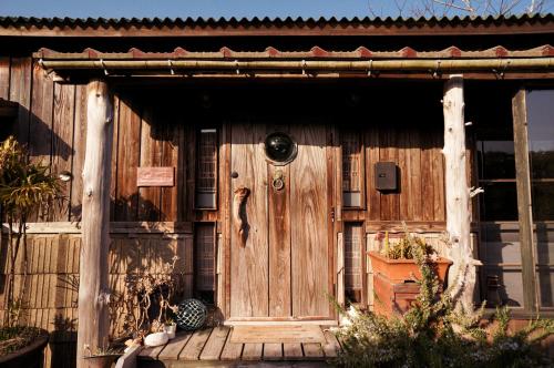 a wooden front door of a wooden house at Yamakujira 焚火とBBQを楽しめる海辺プライベートコテージ 山鯨荘 in Minamiboso