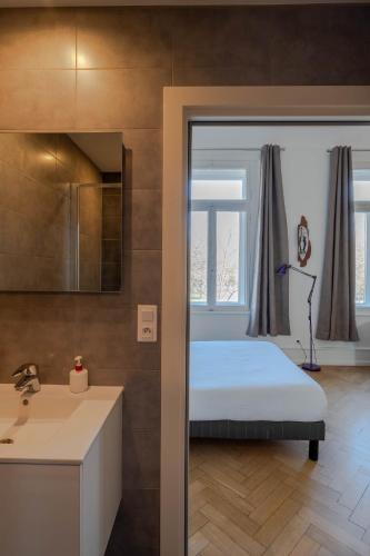 a bedroom with a bed and a sink and a window at La Résidence de l'Orangerie in Strasbourg