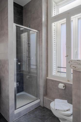 a bathroom with a shower with a toilet and a window at La Résidence de l'Orangerie in Strasbourg