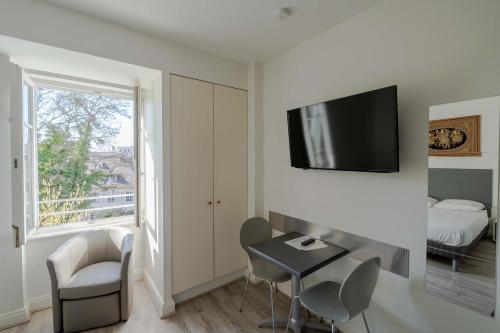 a room with a table and chairs and a window at La Résidence de l'Orangerie in Strasbourg