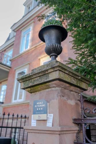 a vase on top of a stone wall in front of a building at La Résidence de l'Orangerie in Strasbourg
