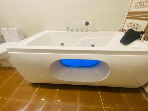 a white bath tub with a blue object in a bathroom at The Signature Hotel Multan in Multan