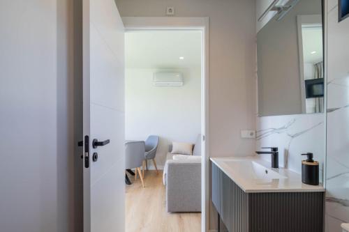 un bagno con lavandino e specchio di Bungalow 2 con piscina en la playa a A Pobra do Caramiñal