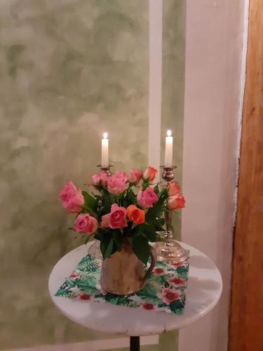 a table with two candles and a vase of flowers at Gemütliches Fachwerkhaus in Reinhausen