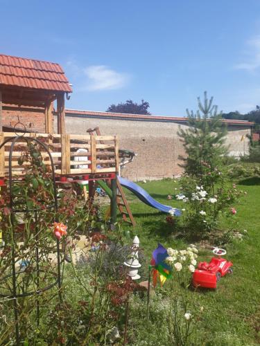 a playground with a slide and a tree in a yard at Gemütliches Fachwerkhaus in Reinhausen