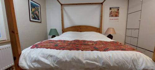 a large bed in a bedroom with two lamps at Le Matin Calme in Porrentruy