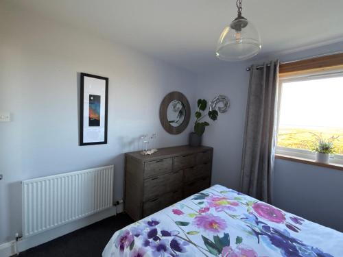 a bedroom with a bed and a dresser and a window at The Fisherman's Snug self catering North Uist in Paible