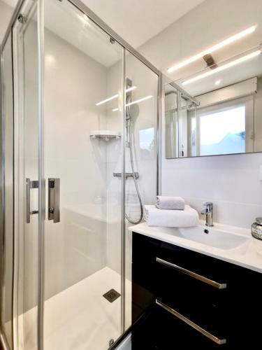 une salle de bain avec une douche en verre et un lavabo dans l'établissement L'Azur - 50 m de la Plage, Wi-Fi, Moderne, Central, à La Baule
