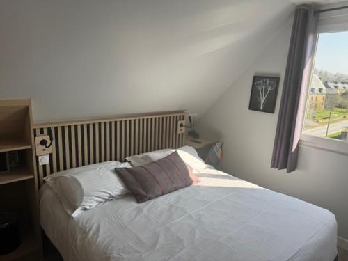 a bedroom with a white bed with a window at The Originals Boutique, Hôtel Les Quatre Salines, Le Mont Saint-Michel Sud in Roz-sur-Couesnon