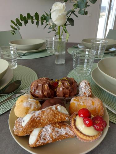 a plate of pastries and donuts on a table at Sikelia Suite Rooftop in Porto Empedocle
