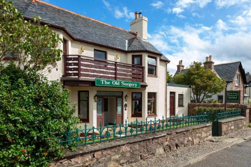 un edificio con un cartello che legge l'indagine sul petrolio di Old Surgery Guest House a Ullapool